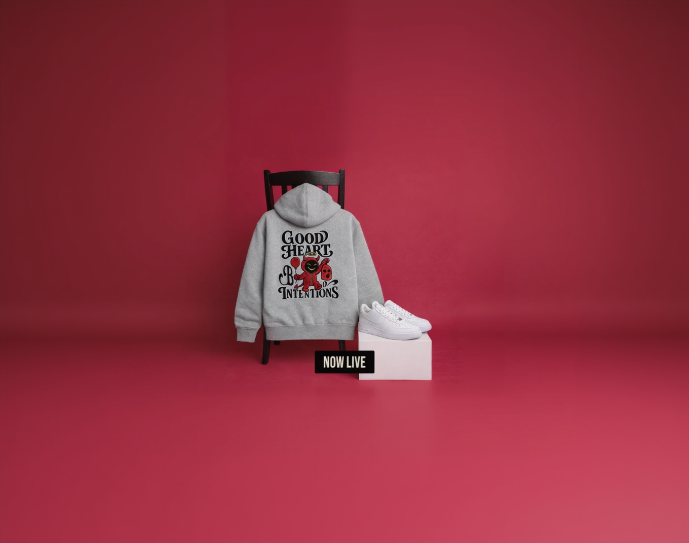 Gray hoodie with text and roses on a chair against a red background